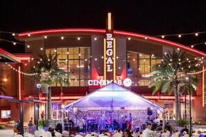 A building with a marquee sign reading 'REGAL CINCINNATI' and a stage set up for an event. - Ultimate Getaway: Yard, BBQ & Games (Gainesville)