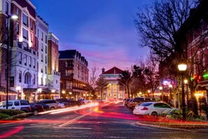 A city street at dusk with buildings, parked cars, and a clear sky. - Ultimate Getaway: Yard, BBQ & Games (Gainesville)