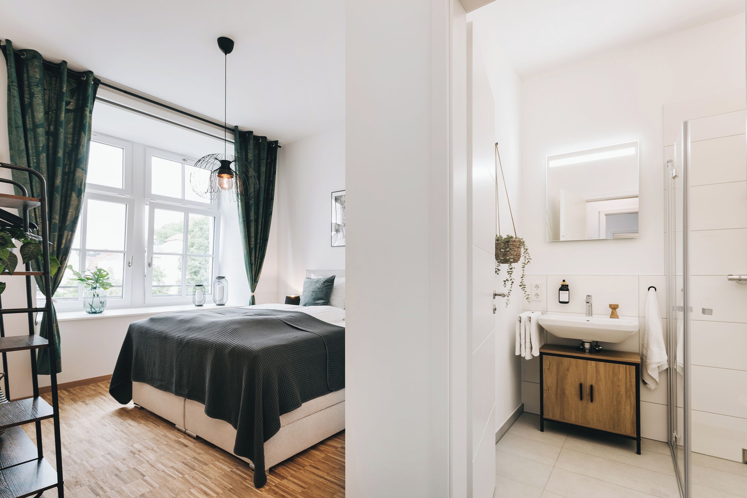 Ein Schlafzimmer mit Bett, Fenster mit Vorhängen, Nachttisch und Beistelltisch.
