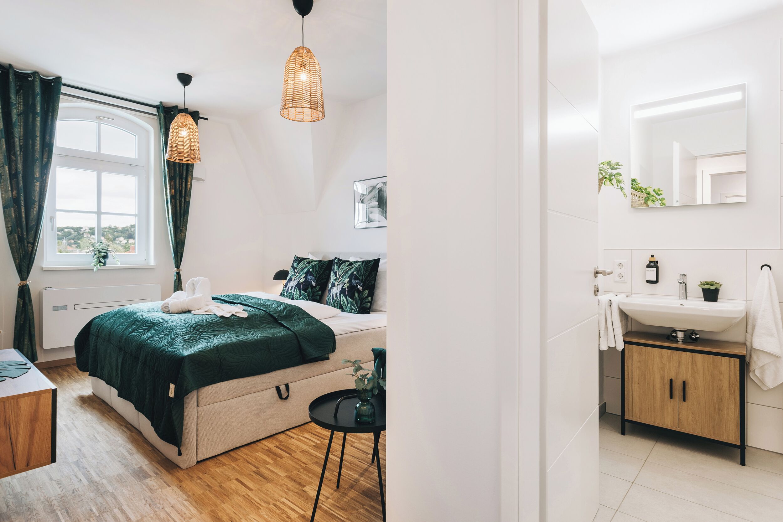 A bedroom with a bed, bedside table, and a hanging light fixture.