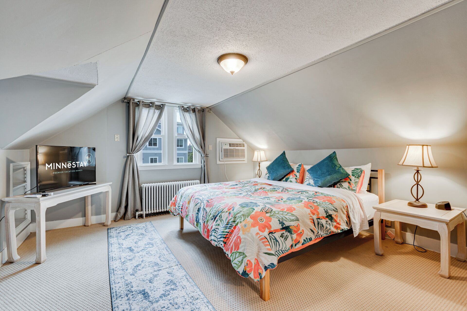 Une chambre à coucher avec un lit, une télévision, un bureau et une fenêtre.