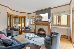 A living room with a fireplace, a television, and comfortable seating. - Harriet House (Minneapolis)