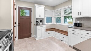 Una cucina moderna con mobili bianchi, una porta marrone e un forno integrato.