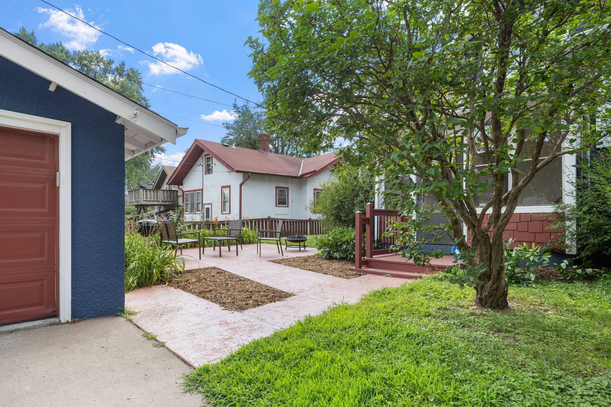 A residential property with a garage, a patio with outdoor furniture, and a well-maintained garden.