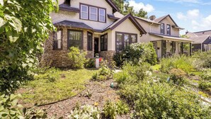 A two-story house with a stone facade, a front porch, and a well-maintained garden. - Lyndale Pleasant Getaway (Minneapolis)