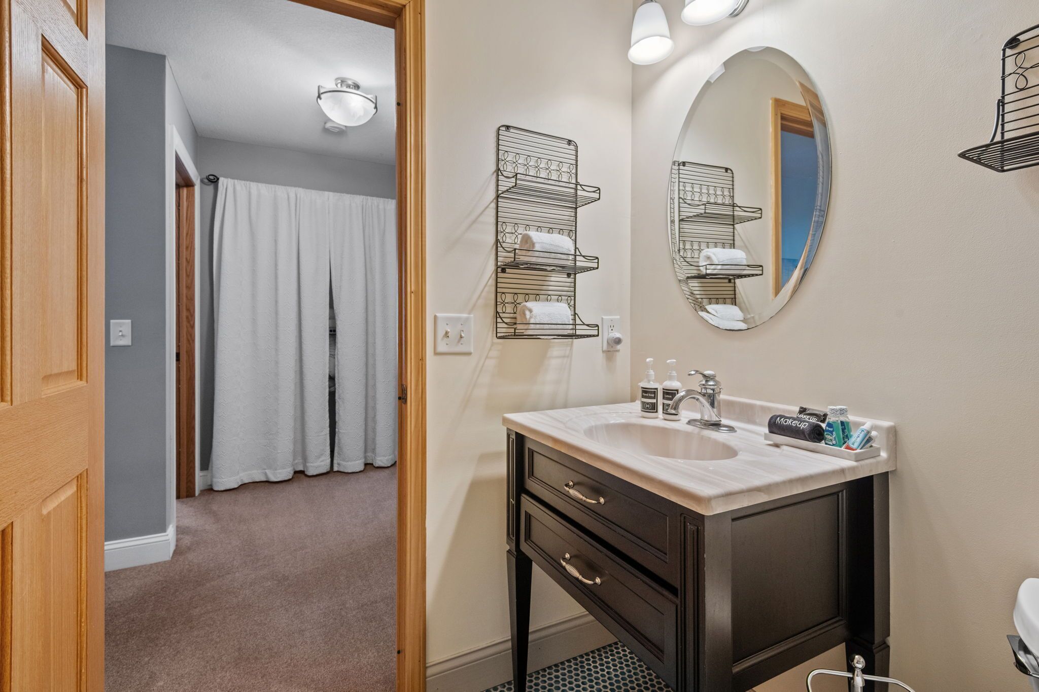 Une salle de bain équipée d’un lavabo, d’un miroir, d’un porte-serviettes et d’un rideau de douche.