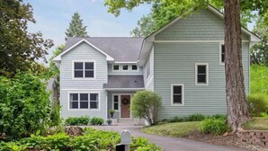 A two-story house with a front porch, a mailbox, and a driveway. - Minnetonka Dream (Wayzata)