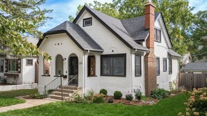 A single-story house with a gabled roof, a brick chimney, and a front porch with steps. - Fulton Gates (Minneapolis)