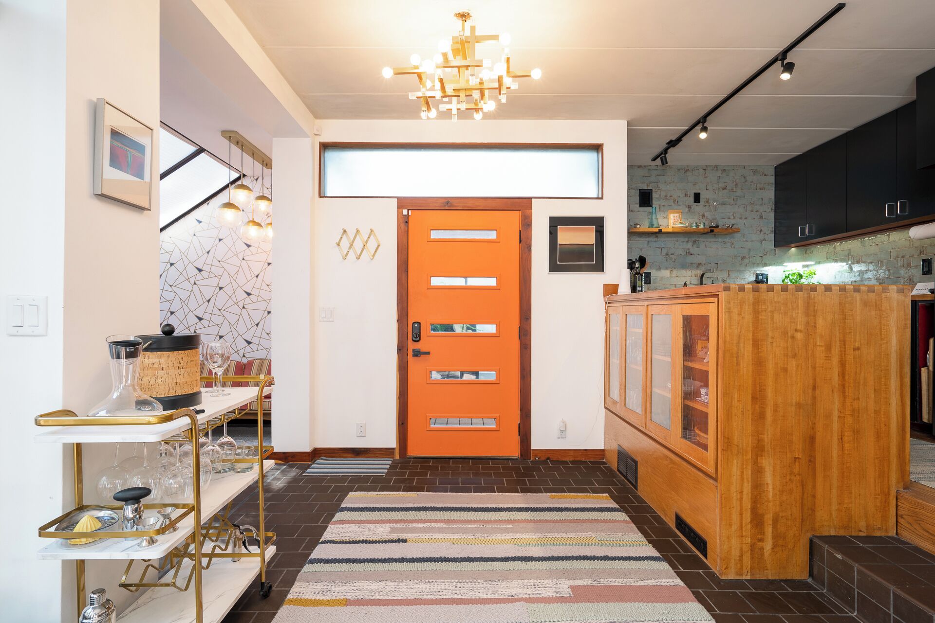 Una cocina moderna con un mueble de madera, una isla de cocina y una alfombra colorida.