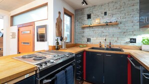 Una cucina moderna con un piano cottura spazioso, un lavello e un ripiano in legno.