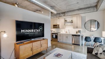 Ein modernes Wohnzimmer mit Flachbildfernseher, Holzschrank und Couchtisch.