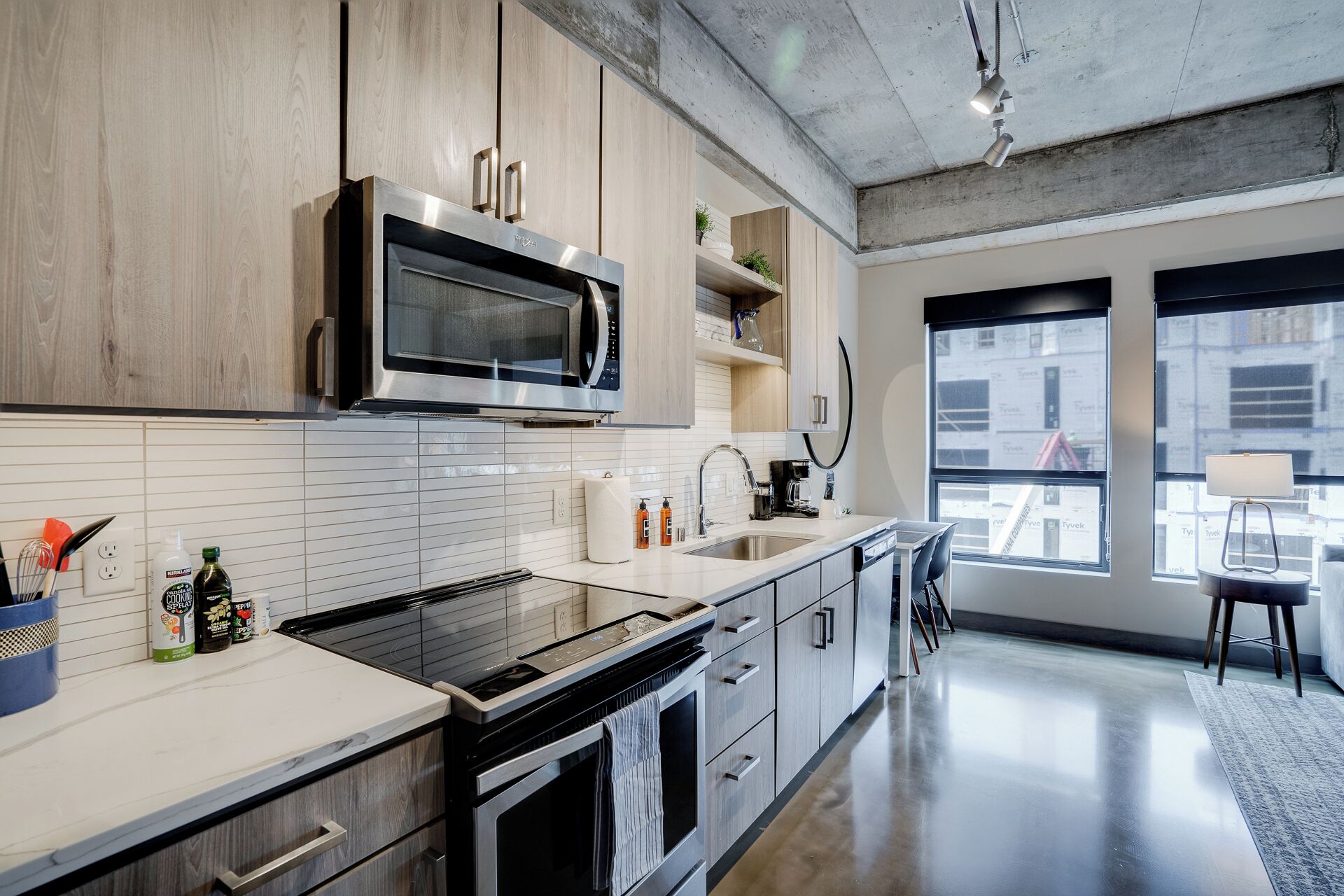 Una cucina moderna con elettrodomestici in acciaio inossidabile, mobili in legno e un'ampia finestra che offre vista sulla città.