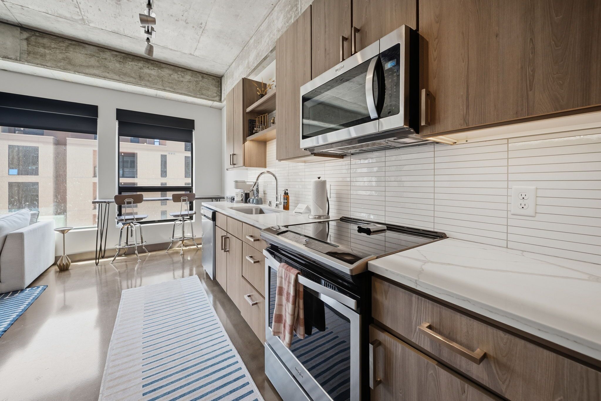 A modern kitchen with wooden cabinets, a stainless steel microwave, and a built-in oven.