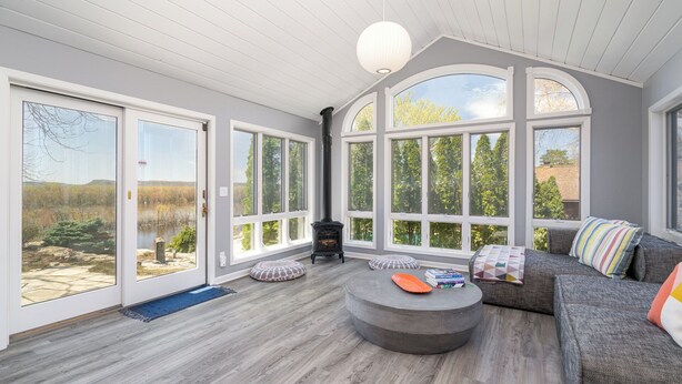 A spacious room with large windows, a fireplace, and a cozy seating area.