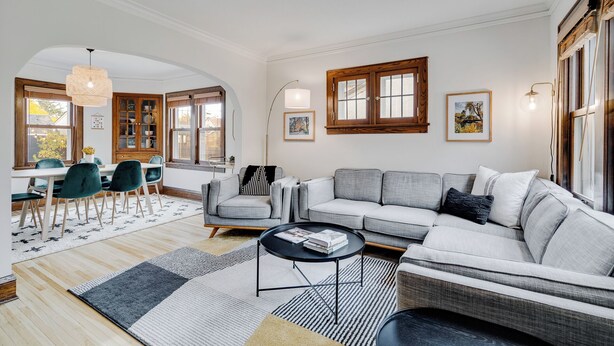 A living room with a sofa, chairs, a coffee table, and a dining area with a table and chairs. - Nokomis Blue (Minneapolis)