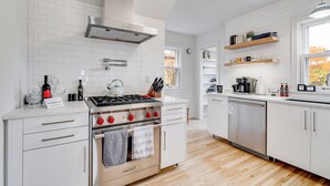 A modern kitchen with white cabinetry, a stainless steel range, and a dishwasher. - Nokomis Blue (Minneapolis)