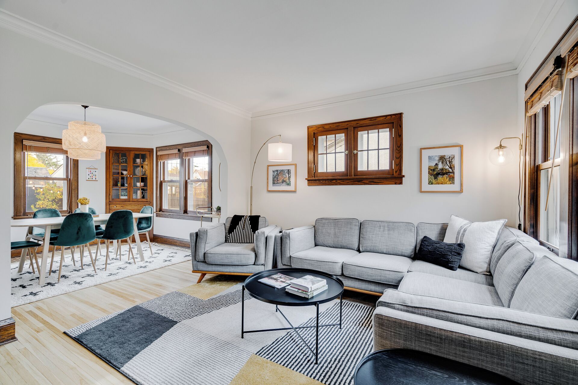 A living room with a sofa, chairs, a coffee table, and a dining area with a table and chairs.