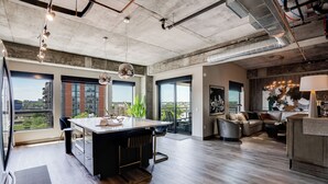 Una cucina moderna con un'isola centrale, ampie finestre e vista sulla città.