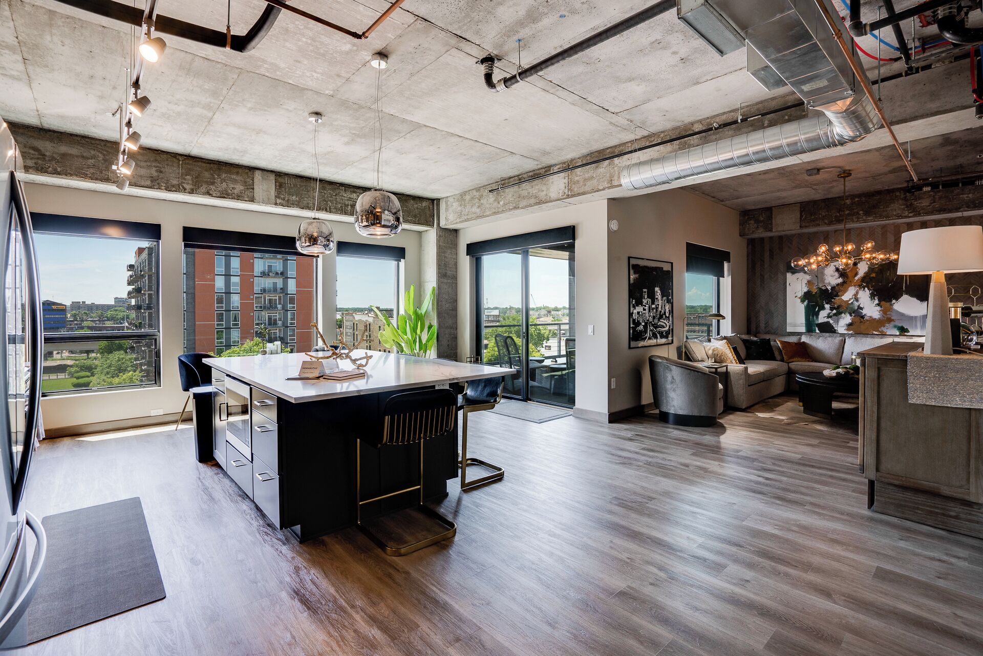 Una cocina moderna con una isla central, ventanas amplias y vistas de la ciudad.