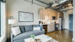 Una sala moderna con un sofá gris, una mesa de centro blanca y un mapa en la pared.