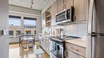 Una cocina moderna con electrodomésticos de acero inoxidable, armarios de madera y un comedor con vistas.