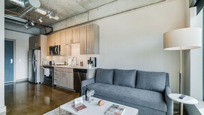 A modern kitchen with wooden cabinets, stainless steel appliances, and a central island. - Sable 607 - Alcove (Minneapolis)