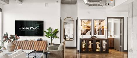 A modern hotel lobby with a reception desk, seating area, and a large mirror.