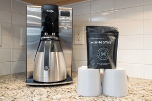 Une machine à café et un paquet de café sur un plan de travail de cuisine.