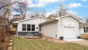 A two-story house with a garage, a front porch with chairs, and a stone pathway leading to the entrance. - D. The Retreat at Linden Hills (Minneapolis)