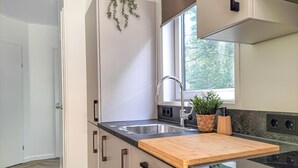 A modern kitchen with a wooden countertop, stainless steel sink, and a window providing natural light. - Nice home in Oosterwolde with WiFi (Oosterwolde)
