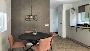 A modern kitchen with white cabinets, a black countertop, and a hanging light fixture. - Nice home in Oosterwolde with WiFi (Oosterwolde)