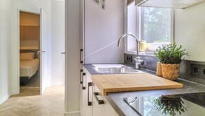 A modern kitchen with a wooden countertop, a built-in sink, and a window providing natural light. - 2 bedroom awesome home in Oosterwolde (Oosterwolde)