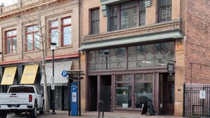 A brick building with large windows and a storefront.