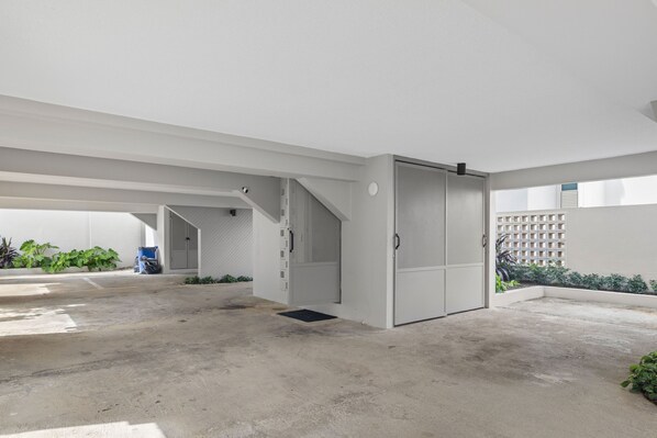 Amplio espacio interior moderno con piso de concreto, una escalera y una puerta que da a otra habitación.