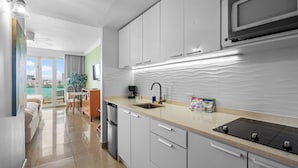 A modern kitchen with white cabinets, a built-in microwave, and a stainless steel refrigerator. - Oceanfront Old San Juan Charm Private Rooftop (San Juan)