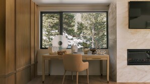 A modern office space with a desk, chair, and a fireplace. - Luxury Modern Mountain Home - Lasata Luxury Rental (Provo)