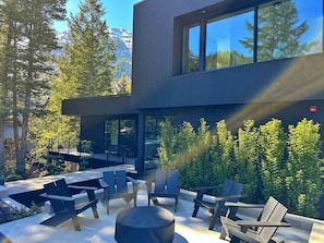 Un espace extérieur moderne, aménagé pour se détendre, avec vue sur une chaîne de montagnes.