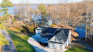 Un barrio residencial con casas, una entrada para vehículos y un lago.
