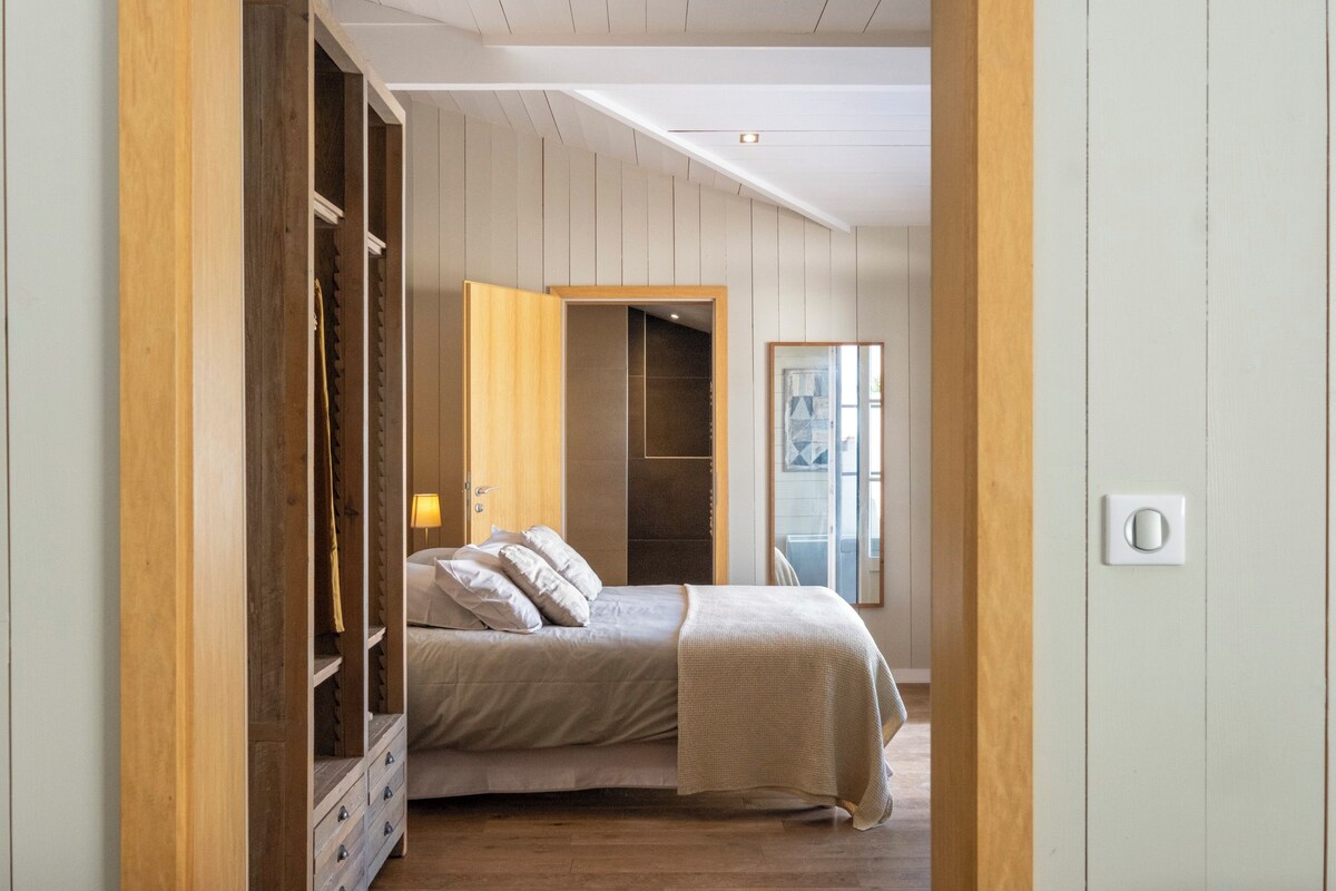 A bedroom with a bed, wooden wardrobe, and a door leading to a bathroom.