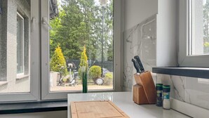 Eine Küche mit Fenster, Schneidebrett, Messerblock und Salz- und Pfefferstreuern.