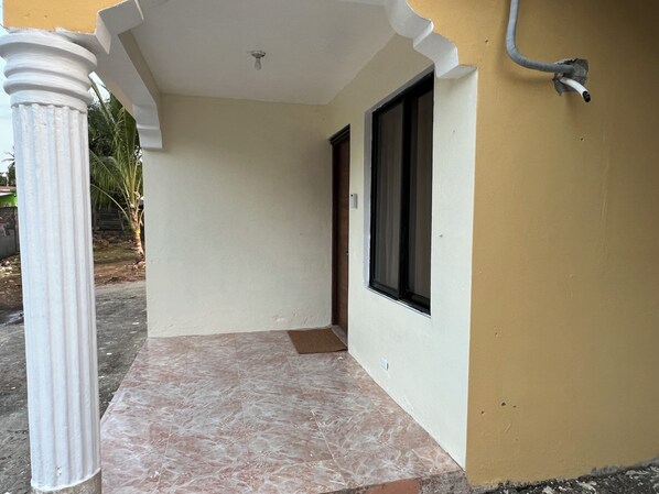 A corridor with a tiled floor, a door, and a window.