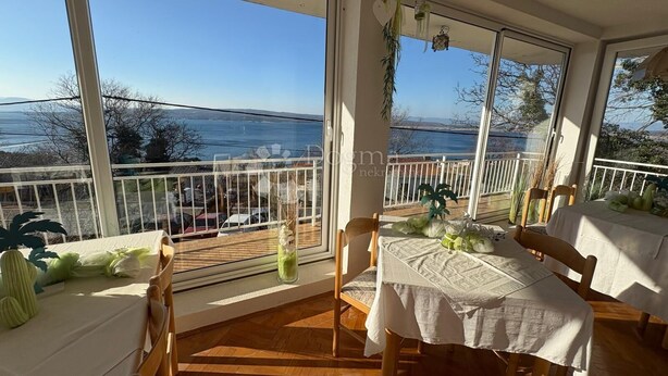 A balcony with a table set for dining, overlooking a scenic view of the sea and hills. - Vila with 25 rooms (Dramalj)