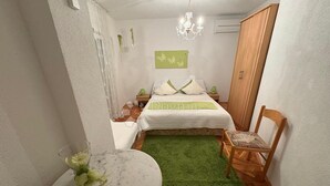 A small, cozy bedroom with a bed, a green rug, a wooden chair, a round table, and a chandelier. - Vila with 25 rooms (Dramalj)