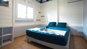 A bedroom with a bed, a window, and a shelf.