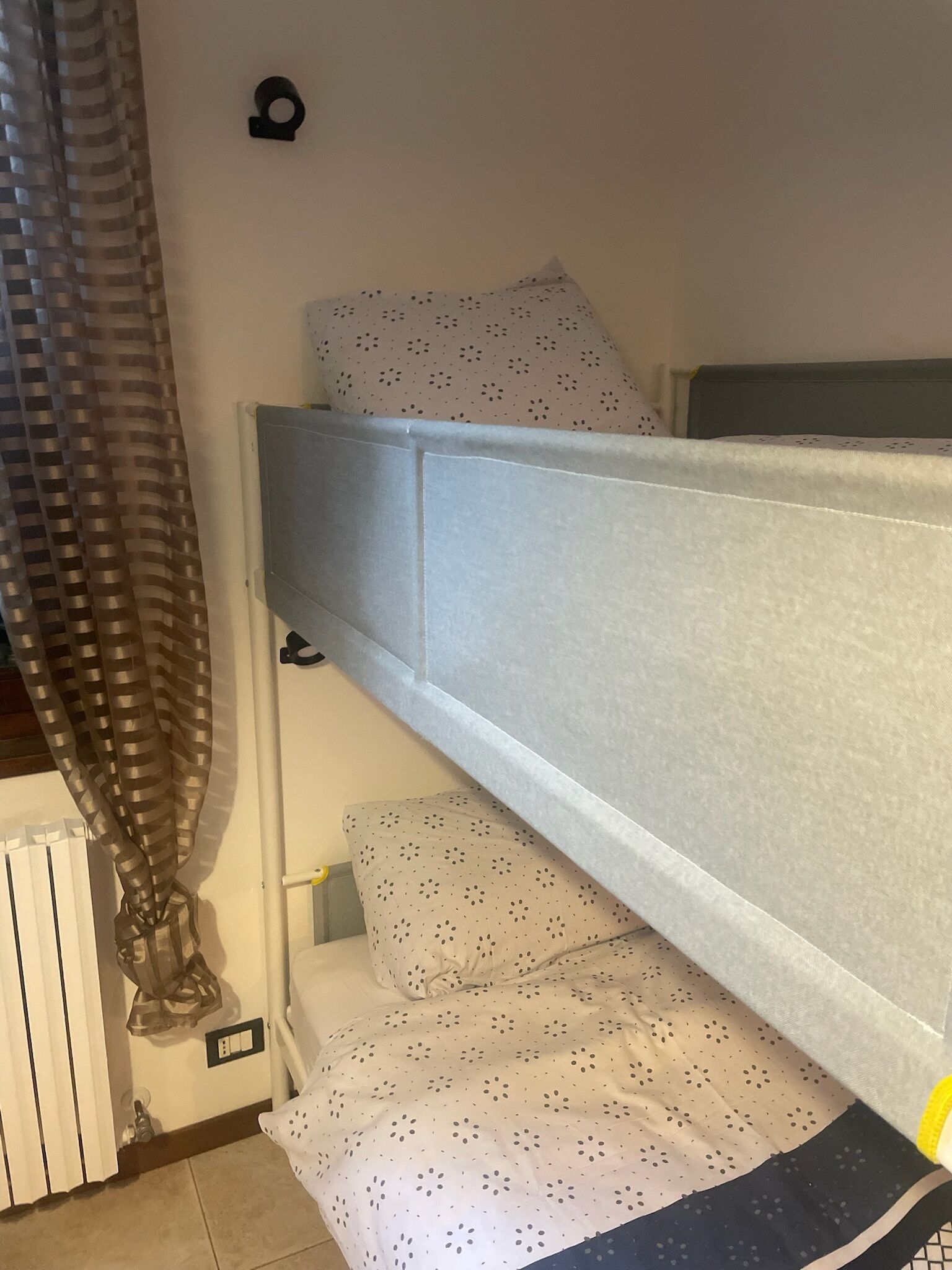 Un letto a castello con materasso bianco e cuscino fantasia.