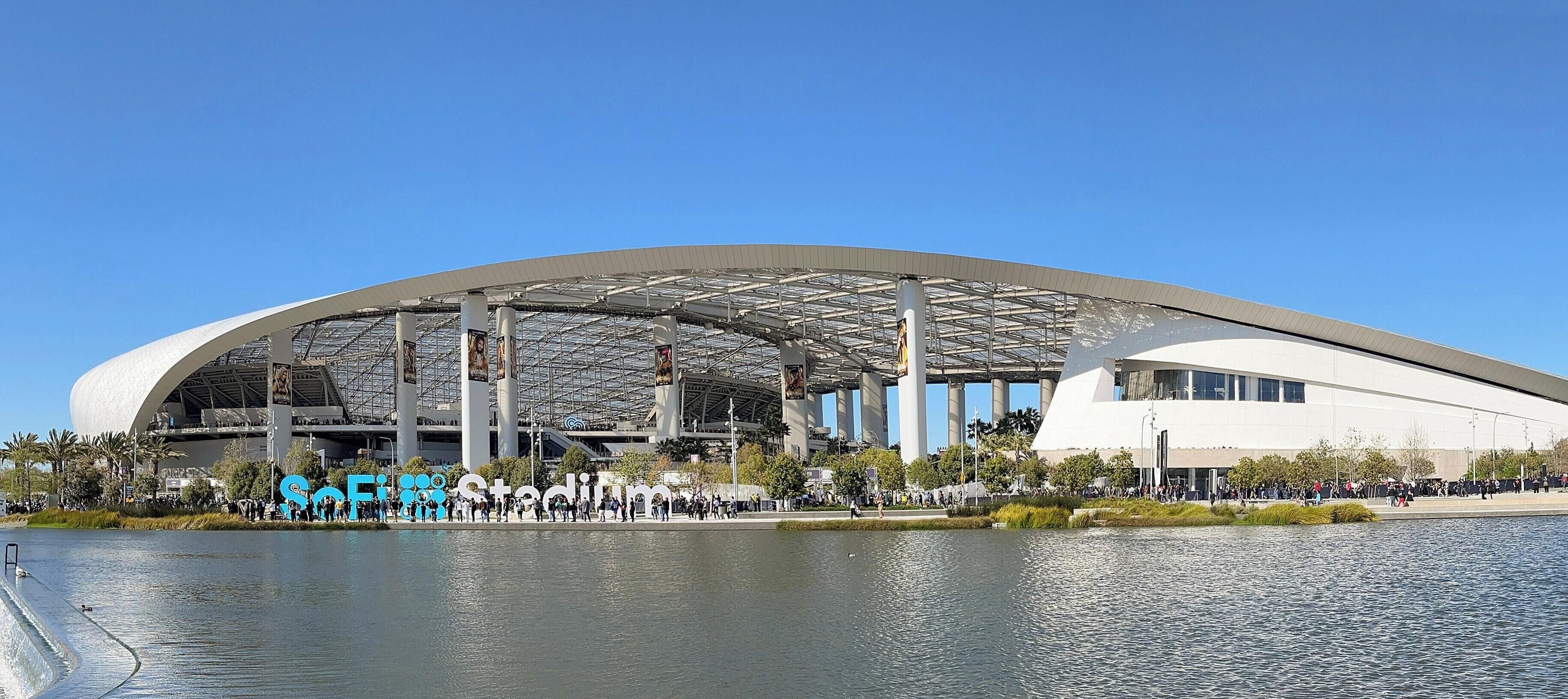 Un stade moderne doté d’une vaste structure ouverte et d’un plan d’eau situé à l’avant.