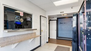 A hotel reception area with a check-in counter, a no smoking sign, and a door to the Encore Inn.