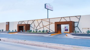 Un motel moderne doté d’une façade géométrique originale et d’une enseigne bien visible.