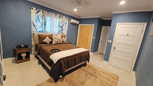 A bedroom with a bed, a nightstand, a wardrobe, and a door. - Charming Modern 1-bedroom apartment with WiFi, AC in Beautiful Nassau (Nassau)