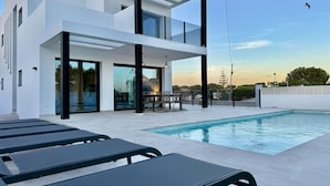 A modern two-story house with a swimming pool, outdoor seating, and large windows. - Vallesa II  - Modern villa with private pool (Calpe)